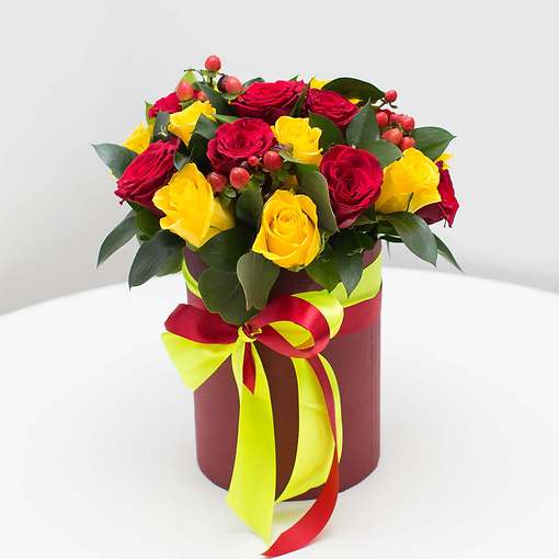 Желтые и красные розы в элегантной шляпной коробке